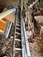 Two aluminum extension ladders leaned in storage area