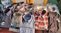 Group of folded new men’s shirts and sweater on table