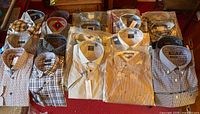 Overview of 20 packaged shirts laid out on floor