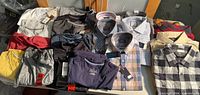 All 20 folded shirts laid out showing variety of colours and tags