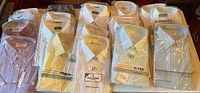 Array of 20 packaged dress shirts showing assortment of colours and brands