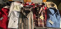 Overview of 20 packaged and tagged men’s shirts on table