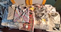 Overview of stacked packaged shirts showing variety of colors and brands