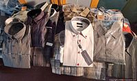 Group of neatly folded new men’s shirts, tags visible