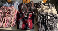 Six of the eight striped/patterned hoodie sweaters folded on table