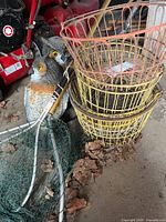 Two plastic owl decoys, two fishing nets, stack of orange and yellow wire baskets