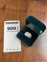 Ring in presentation box beside lot card