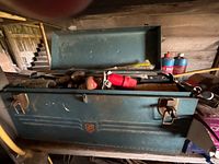 Blue-green metal toolbox with hand tools inside