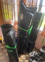 Multiple black molded plastic vehicle liners and storage accessories standing upright
