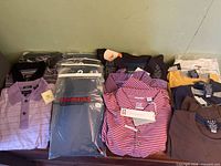 Group shot of all packaged and tagged shirts laid out on surface
