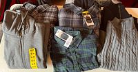 Overall view of six folded garments showing colours, patterns and size stickers