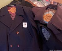 Two Weather Report overcoats and part of MacMor coat showing lapels, buttons, quilted linings