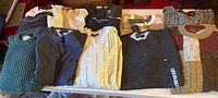 All sweaters folded on table showing quantity and variety