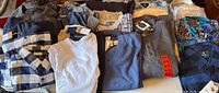 Group shot of all folded shirts and sweaters on table