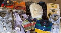 Overview of all shirts laid out showing polos and dress shirts, tags visible