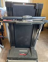 Front view of folded Pro-Form 585Pi treadmill showing deck, console, and attached cord