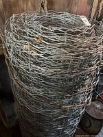 Full view of rolled galvanized wire fencing showing mesh pattern and rope tie