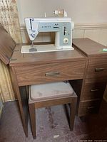 Singer Touch & Sew Model 648 sewing machine mounted in cabinet with stool visible