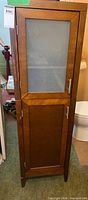 Full frontal view of cabinet showing frosted upper door and lower solid doors