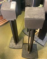 Two Zenith cube speakers mounted on black pedestal stands
