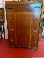 Front view of five-drawer dresser showing veneer finish, inlays, brass pulls