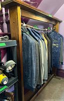 Full view of wooden garment rack with hanging rod and sample clothing (not included)
