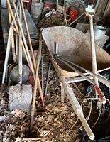Overall lot with wheelbarrow and tools on leaf-covered floor