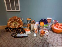 Group shot showing entire lot including wreath, tableware, luminaries, bowls, tea light house, carving kits, treat bags