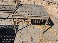 Square cast metal side table showing lattice top, rope edge and legs