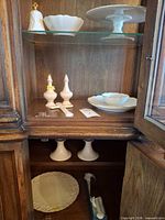 Cabinet view showing cake stand, bowl, bell, salt & pepper, small plate, candlesticks, platter and boxed items