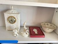 All six Lenox porcelain items grouped on shelf: clock, three animal figurines, ornament in red box, openwork bowl