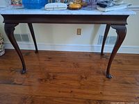 Full view of marble top table showing dimensions and leg design