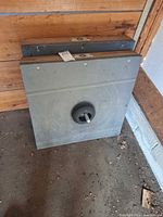 front view of stacked metal quoits bases leaning against wall