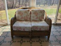 Front view of wicker loveseat showing frame and cushions