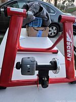 Full view of red Ascent trainer frame with fluid resistance unit attached