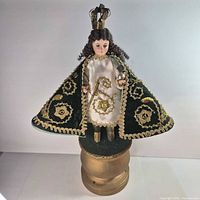 Full view of Santo Niño de Cebú statue with cape spread on pedestal