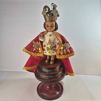 Full view of Santo Niño de Cebu statue on pedestal with crown, cape and tunic