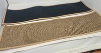 Two carpet stair treads showing front woven surface and black rubber backing