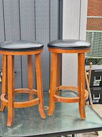 Both wooden bar stools showing overall design and condition