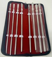 Full open case showing eight urethral sounds secured with elastic bands