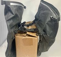 Overall view of both panniers draped over a box showing exterior surfaces