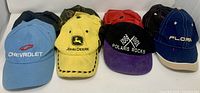 Front view showing Chevrolet, John Deere, Polaris Rocks, Floria and additional hats behind