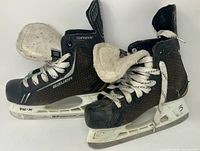 Side view of both skates showing uppers, laces, holders and blades