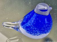 Side view of blue and clear glass bird paperweight