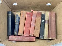 Nine standing hardcovers plus one lying flat in cardboard box