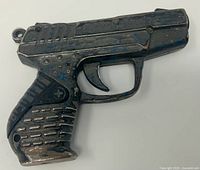 left side view of gun-shaped lighter showing overall form, trigger, grip texture, key ring loop