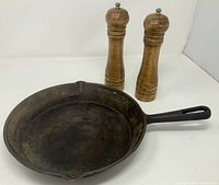 Top view of cast iron skillet and two wooden mills
