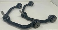 Two black upper control arms with ball joints and bushings