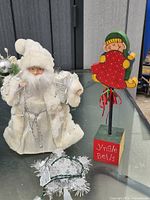 Santa figurine, wood elf stand, tinsel light strand