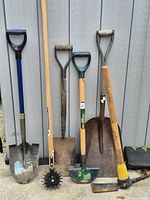All six garden tools leaning against wall